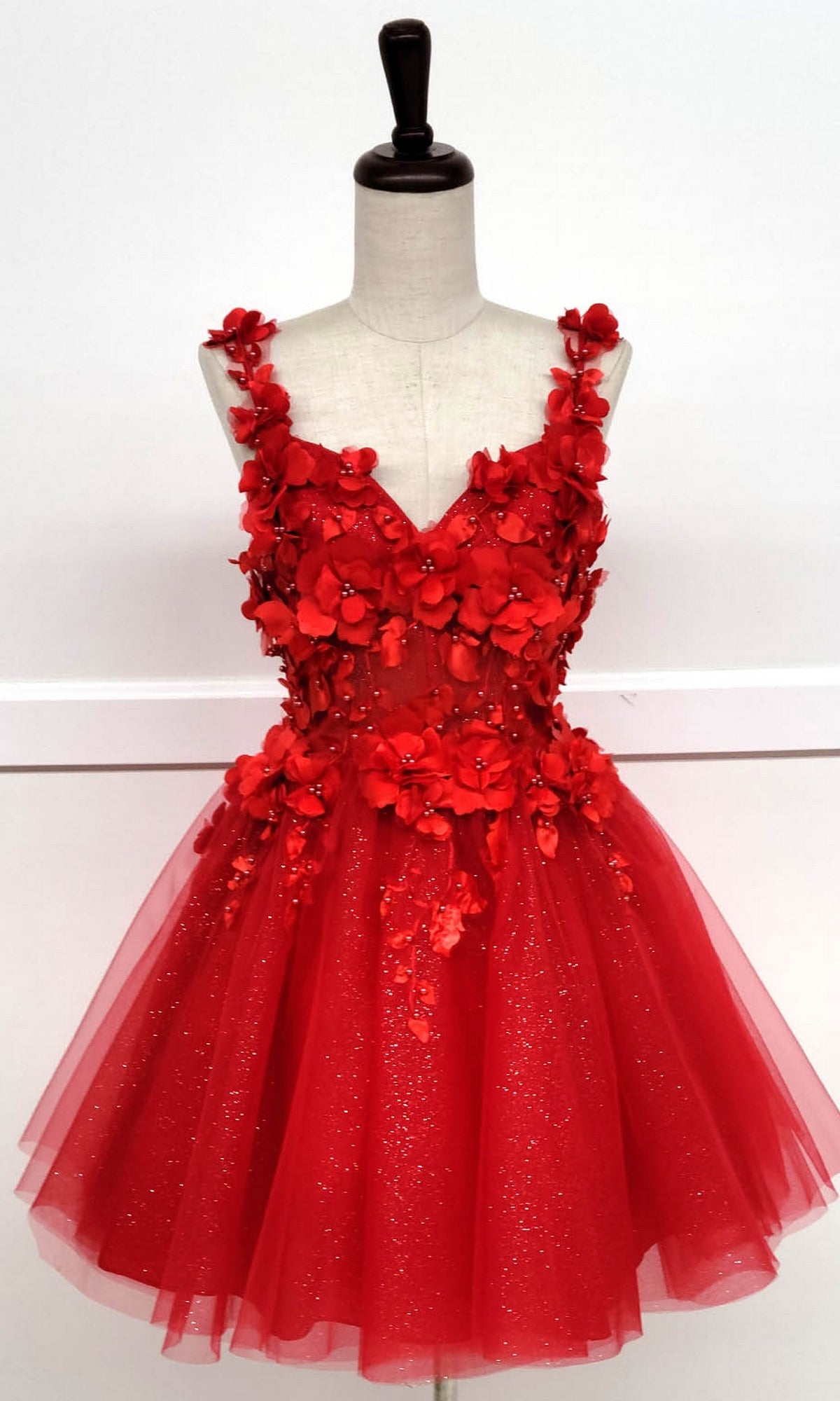 The Floral-Bodice Short Babydoll Homecoming Dress C321 features a sleeveless red floral bodice with 3D appliqués and a glittery tulle skirt, creating a playful, elegant short A-line silhouette perfect for special occasions.